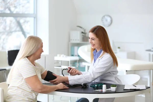 Médico Que Mede Pressão Arterial Mulher Madura Clínica — Fotografia de Stock
