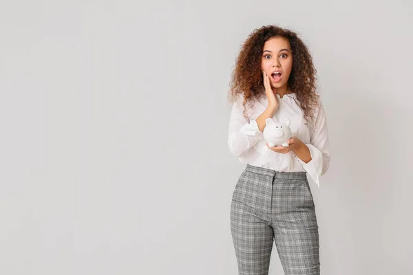 Surprised African American Woman Piggy Bank Light Background — Stock Photo, Image