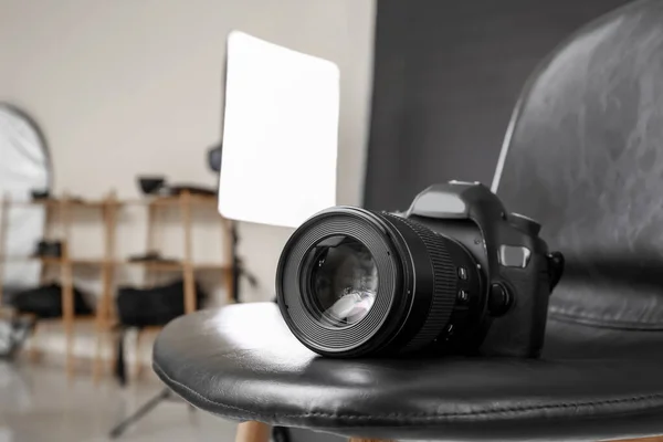 Modern camera on chair in professional photo studio