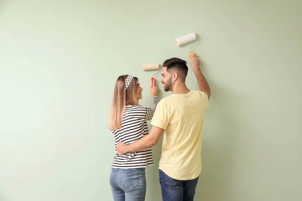 幸福的年轻夫妇在新房子里粉刷墙壁 — 图库照片