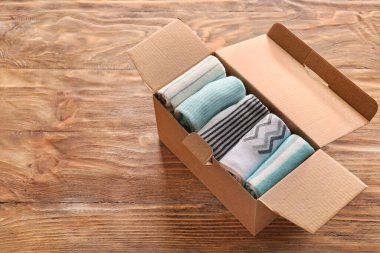 Ahşap arka planda farklı çoraplarla dolu bir kutu