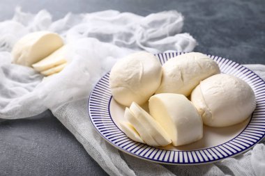 Koyu arkaplanda mozzarella peyniri olan tabak.