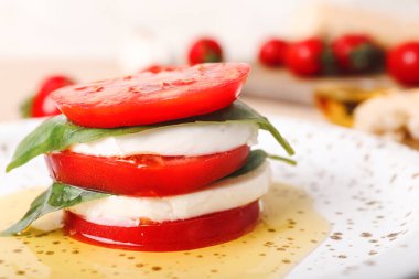 Domatesli Mozzarella peyniri, fesleğen ve yağlı tabak, yakın plan.