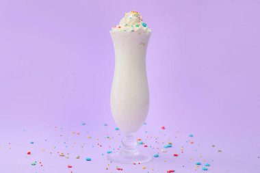 Glass of tasty milkshake on color background