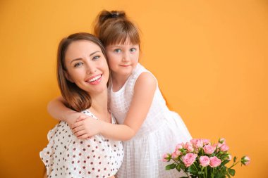 Küçük kız renkli arka planda annesini selamlıyor.