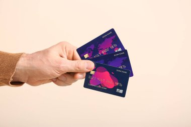 Hafif arkaplanda kredi kartları olan bir erkek.