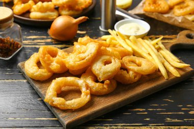 Çıtır soğan halkaları, sos ve patates kızartması.