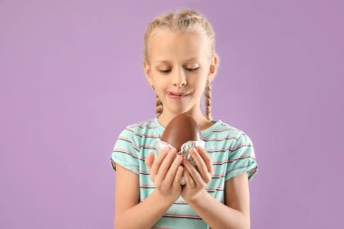 Renkli çikolata yumurtası olan tatlı küçük bir kız.