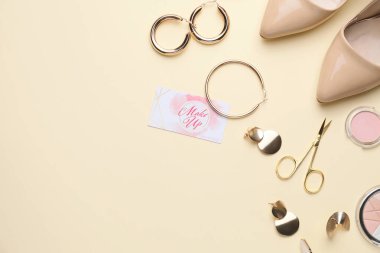 Dekoratif kozmetik ürünleri ve aksesuarlar. Renkli arka planda makyaj sanatçısının kartviziti var.