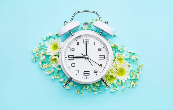 色の背景に花と目覚まし時計 — ストック写真