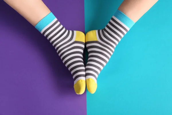 Legs of woman in socks on color background