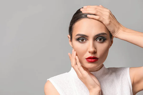 Mujer Joven Con Hermoso Maquillaje Sobre Fondo Gris — Foto de Stock