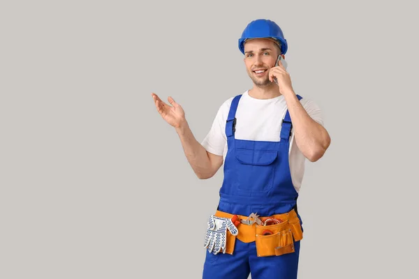 Snygg Manlig Arbetare Talar Telefon Grå Bakgrund — Stockfoto