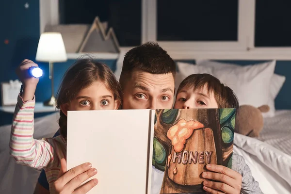 爸爸和他的孩子们在家里读睡前故事 — 图库照片