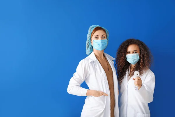 Жінки Лікарі Захисними Масками Термометром Кольоровому Фоні Концепція Епідемії — стокове фото