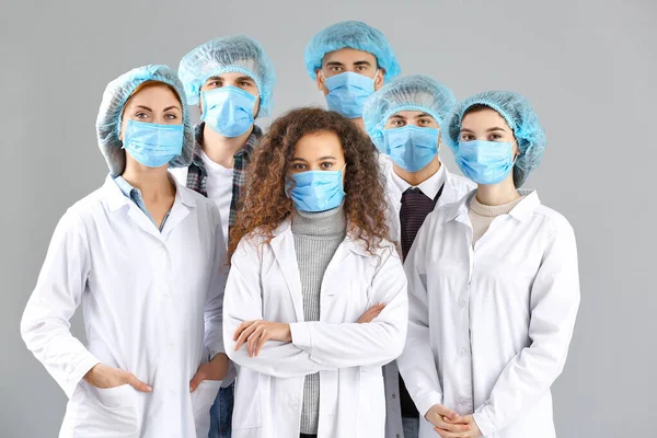 Gruppe Von Ärzten Mit Schutzmasken Auf Grauem Hintergrund Konzept Der — Stockfoto