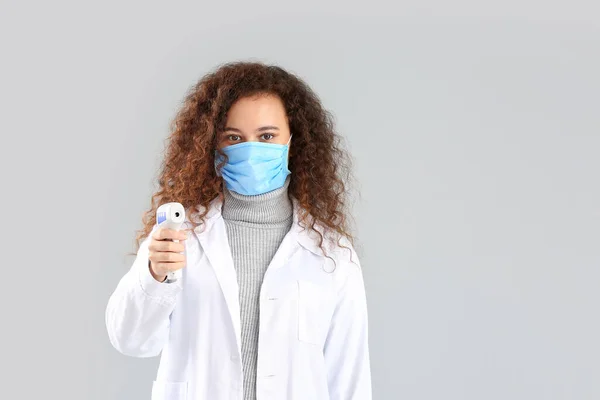 Vrouwelijke Arts Met Beschermend Masker Thermometer Grijze Achtergrond Begrip Epidemie — Stockfoto
