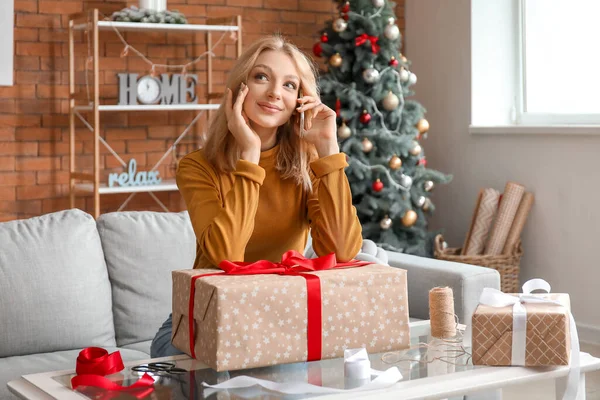 Beautiful Young Woman Talking Phone While Wrapping Christmas Gifts Home — Stock Photo, Image