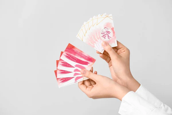 Mãos Femininas Com Cartões Visita Maquiador Fundo Cinza — Fotografia de Stock