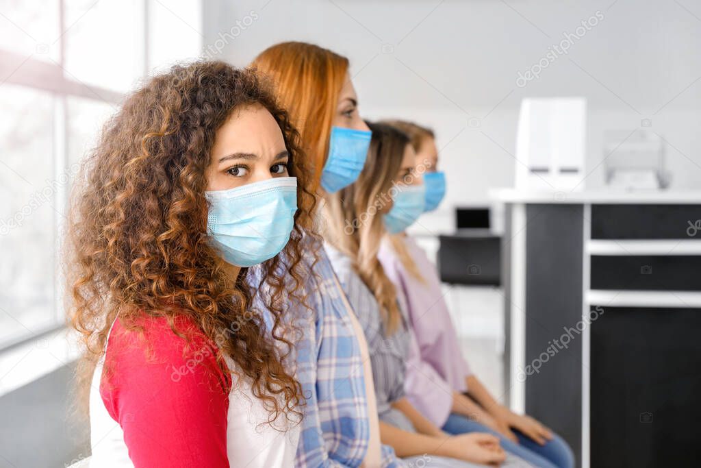 Patients with protective masks sitting in hall of clinic. Concept of epidemic