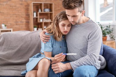 Evde hamilelik testi olan üzgün genç bir çift.