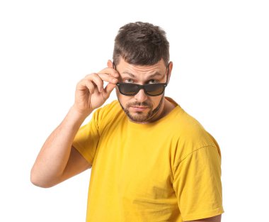 Beyaz arka planda güneş gözlüklü yakışıklı bir adam.