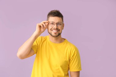 Renkli arka planda gözlüklü yakışıklı bir adam.