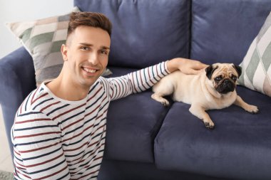 Evde sevimli köpekli yakışıklı bir adam var.