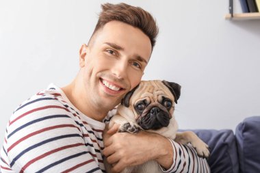 Evde sevimli köpekli yakışıklı bir adam var.