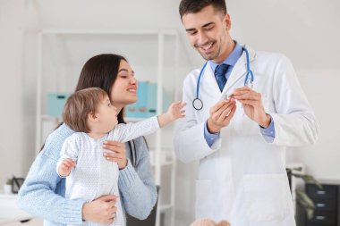 Küçük bebek li kadın klinikte çocuk doktorunu ziyaret etti