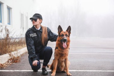 Sokakta devriye gezen köpekli kadın polis.