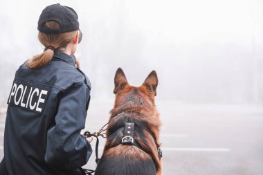 Sokakta devriye gezen köpekli kadın polis.