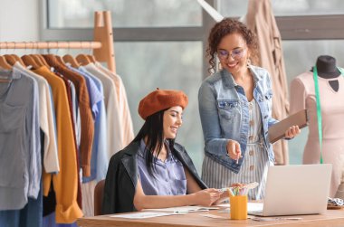 Ofiste çalışan kadın giyim tasarımcıları