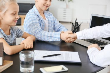 Müvekkilleri ofiste el sıkışan küçük bir emlakçı.