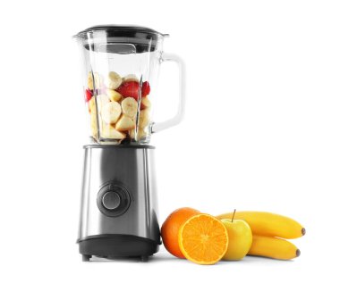 Beyaz arka planda sağlıklı meyve püresi için malzemelerle karıştırıcı