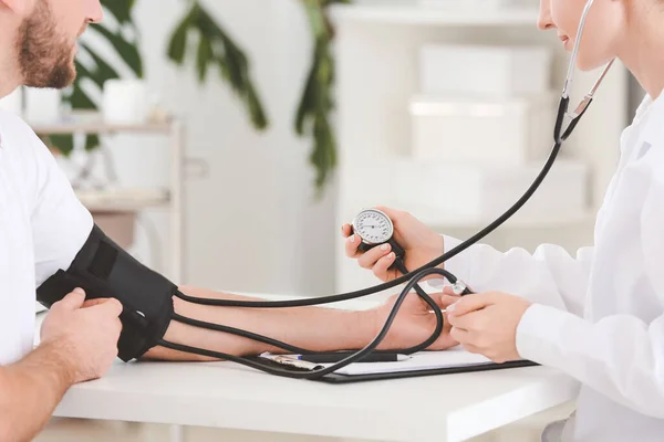 Female Doctor Measuring Blood Pressure Male Patient Hospital — Stock Photo, Image