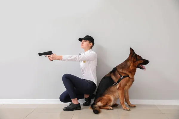 Vrouwelijke Politieagent Met Hond Bij Lichte Muur — Stockfoto