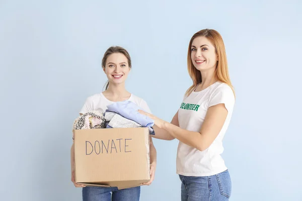 Voluntarios Con Donaciones Para Personas Pobres Sobre Fondo Color — Foto de Stock