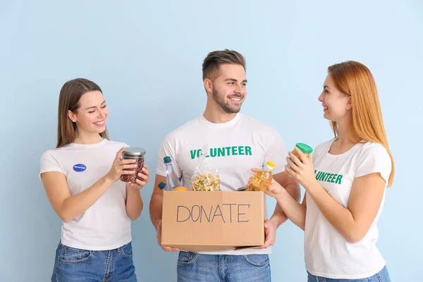 Voluntarios Con Donaciones Para Personas Pobres Sobre Fondo Color — Foto de Stock