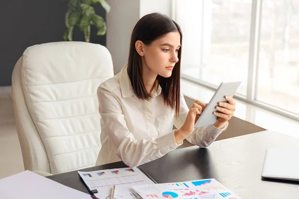 Young businesswoman with tablet computer working in office