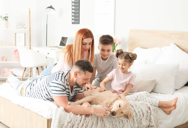 Happy family with dog in bedroom at home