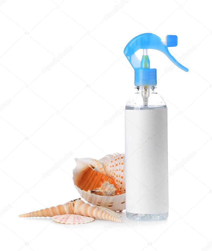 Bottle of air freshener and sea shells on white background
