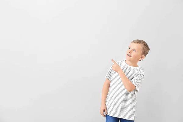 Roztomilý Chlapec Ukazuje Něco Světlém Pozadí — Stock fotografie