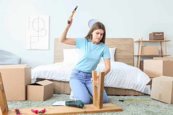 Angry woman assembling furniture at home