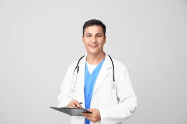Hafif arka planda yakışıklı erkek doktor.