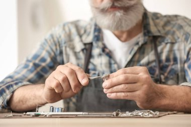 Kuyumcu atölyede yüzük yapıyor.