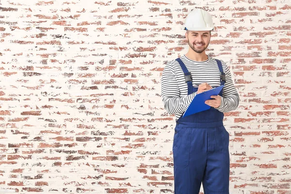 Handsome Male Worker Clipboard Brick Background — Stock Photo, Image