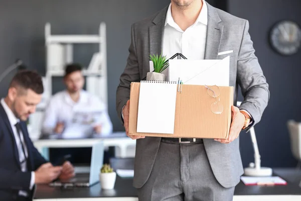 Fired man with personal stuff in office