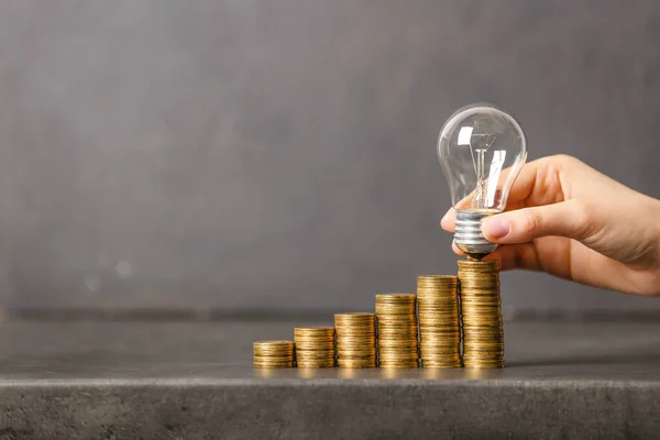 Female Hand Light Bulb Coins Grey Background Concept Savings Money — Stock Photo, Image