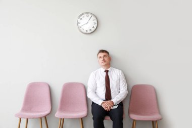 Olgun bir adam iş görüşmesini içeride bekliyor.